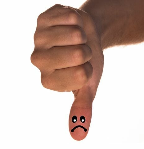 Sad face drawn on thumb.