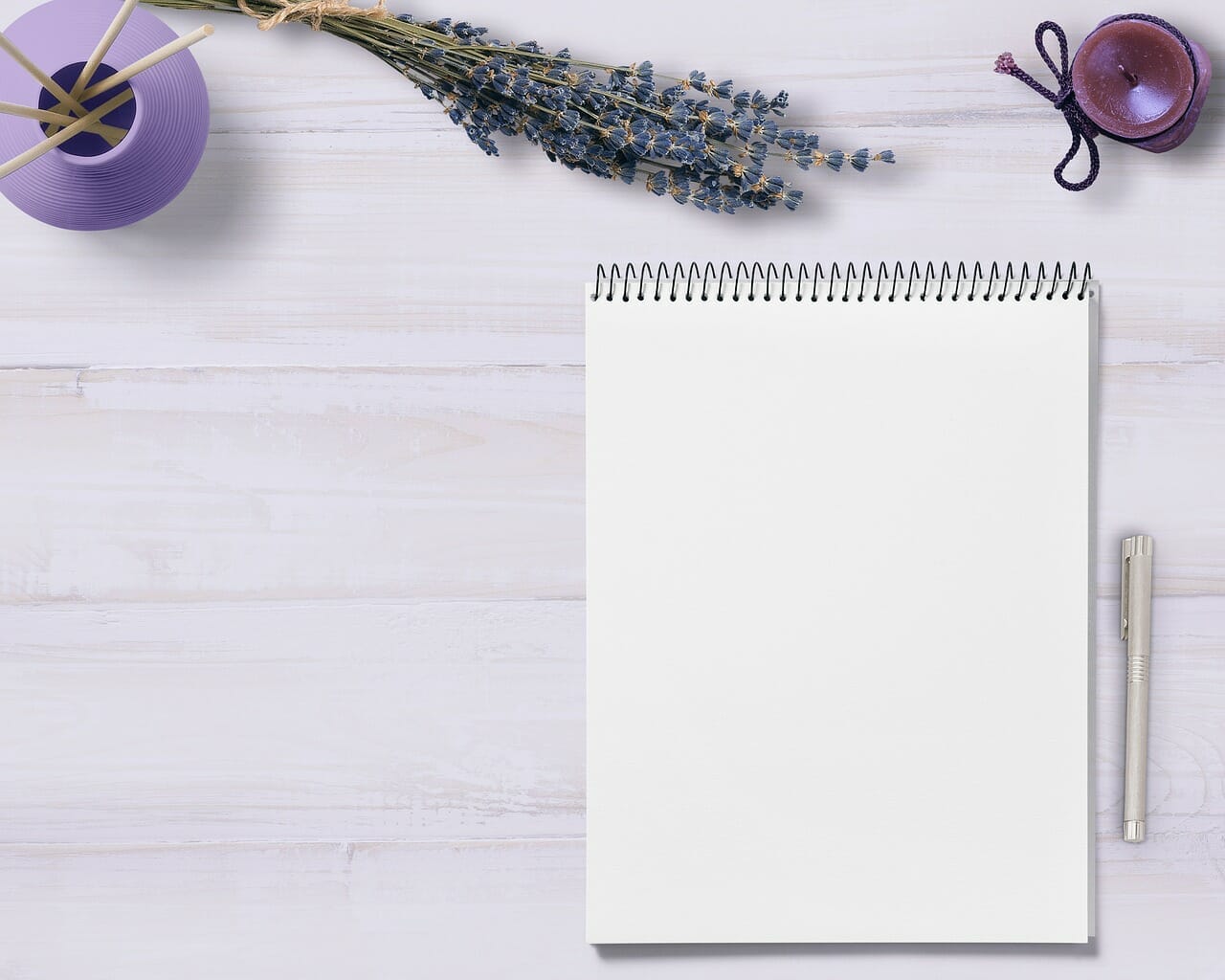 A blank notebook adorned with lavender flowers on a wooden table, perfect for mind maps.