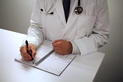 A physician penning notes while dressed in a H&P Notebook - Medical History and Physical Notebook, 100 Medical templates with Perforations.